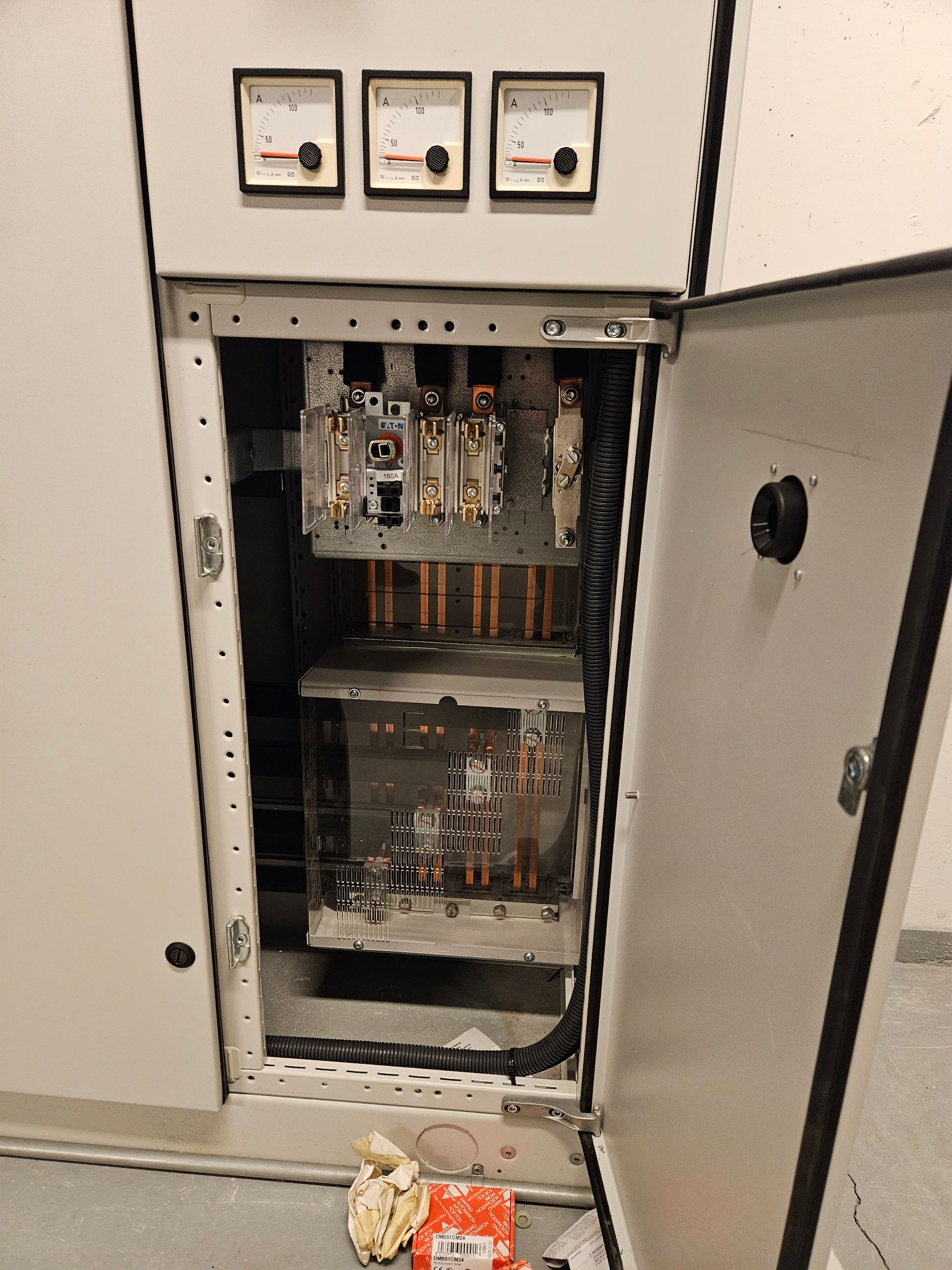 Et elskab med åben dør og en masse ledninger, der stikker ud af det.