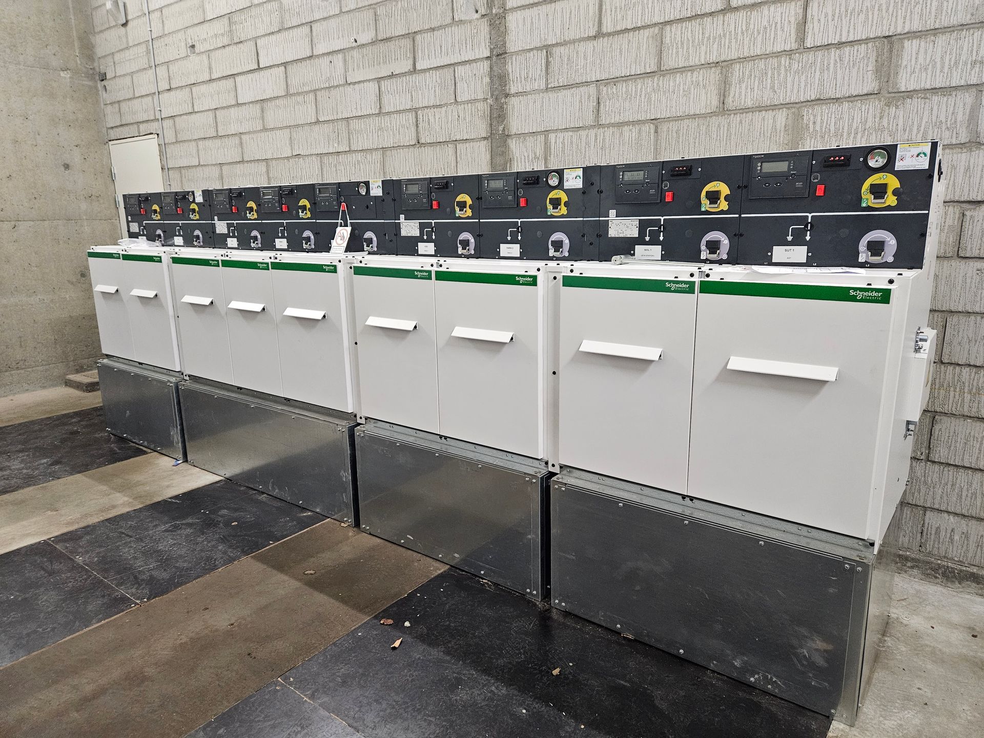 En række hvide skabe er opstillet op ad en murstensvæg.