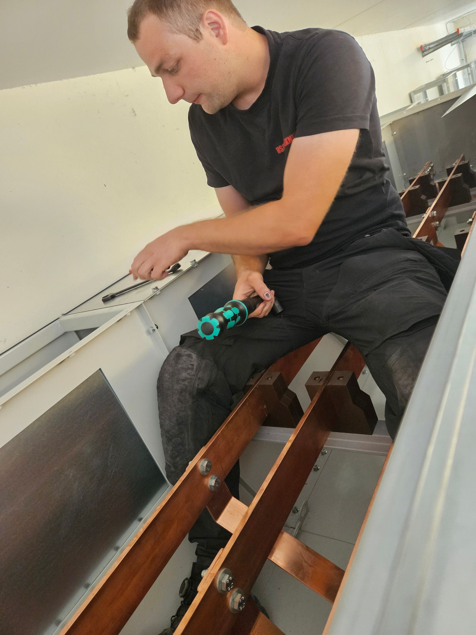 En mand i en sort skjorte arbejder på et stykke træ