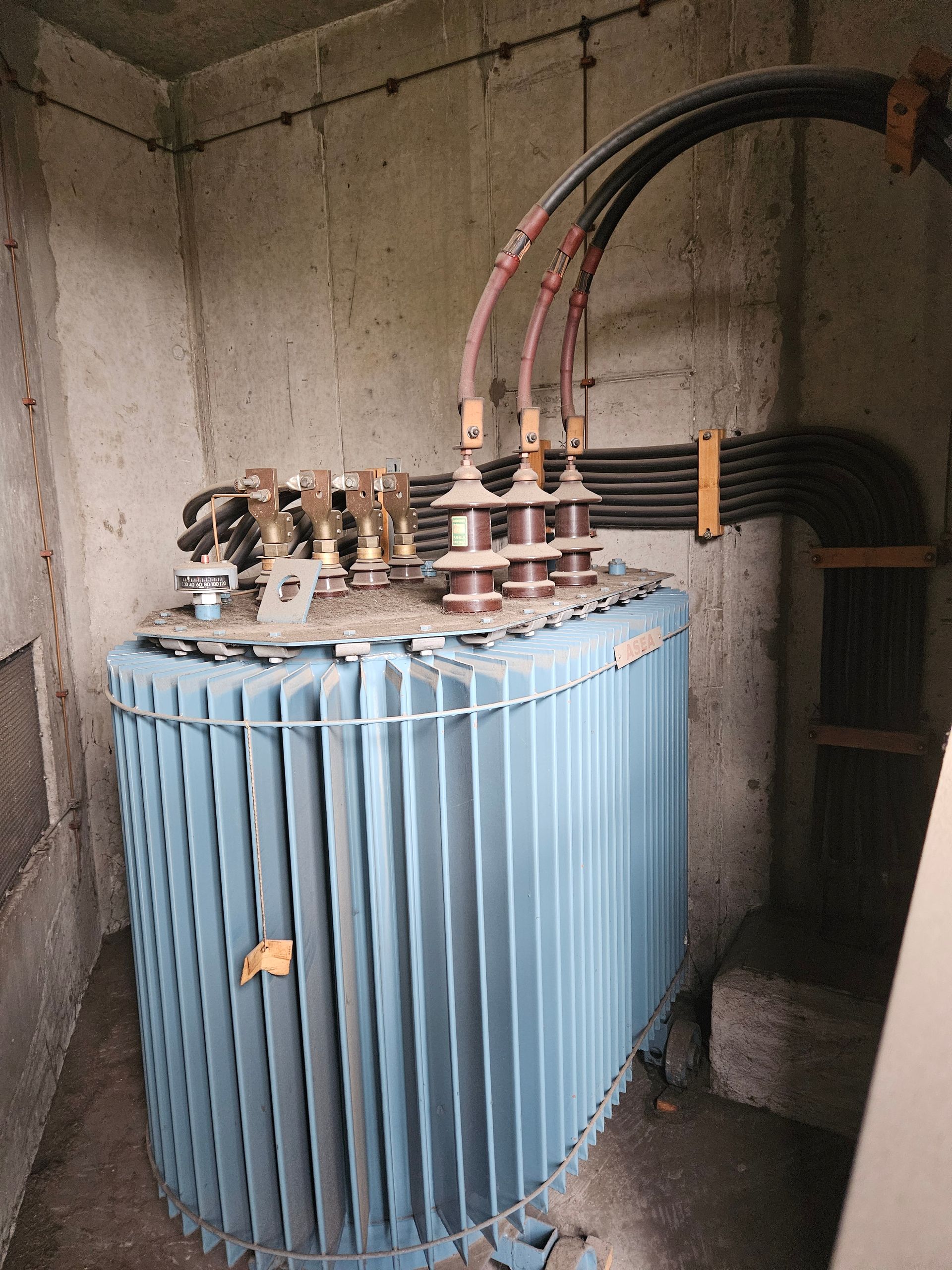 En stor blå elektrisk transformer står i et rum