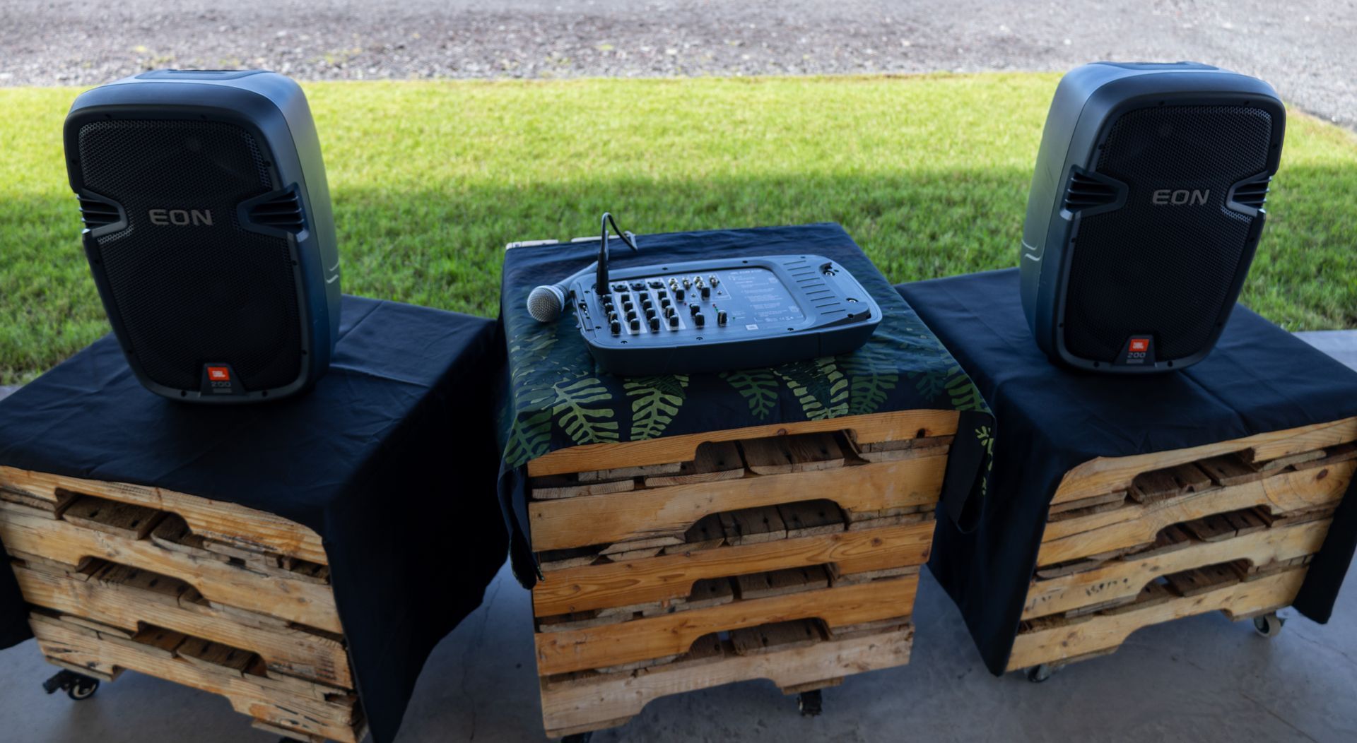 Two speakers are sitting on top of wooden pallets.