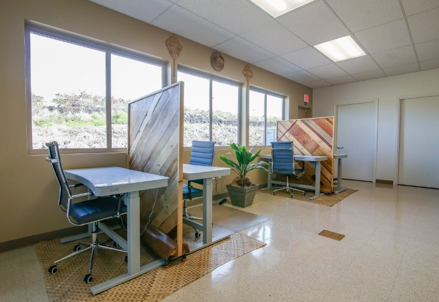 A room with a lot of windows and tables and chairs.