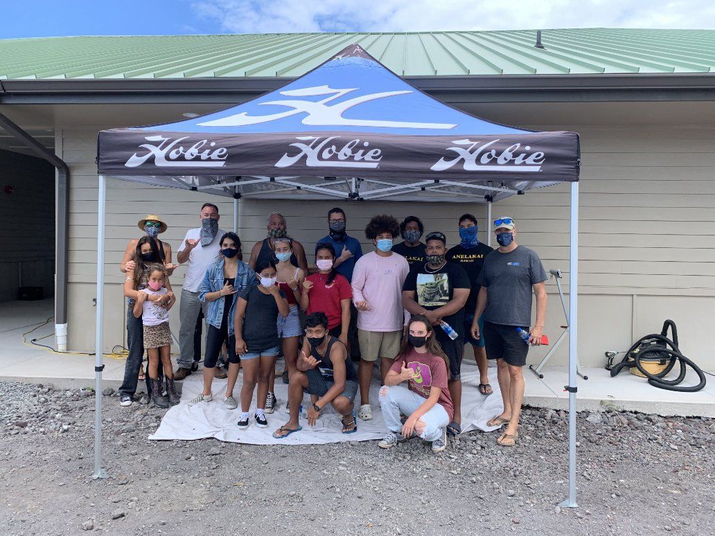 A group of people are posing for a picture under a tent.