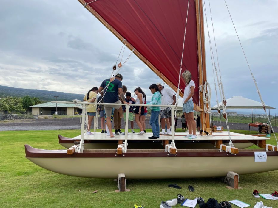 A group of people are standing on the deck of a boat.