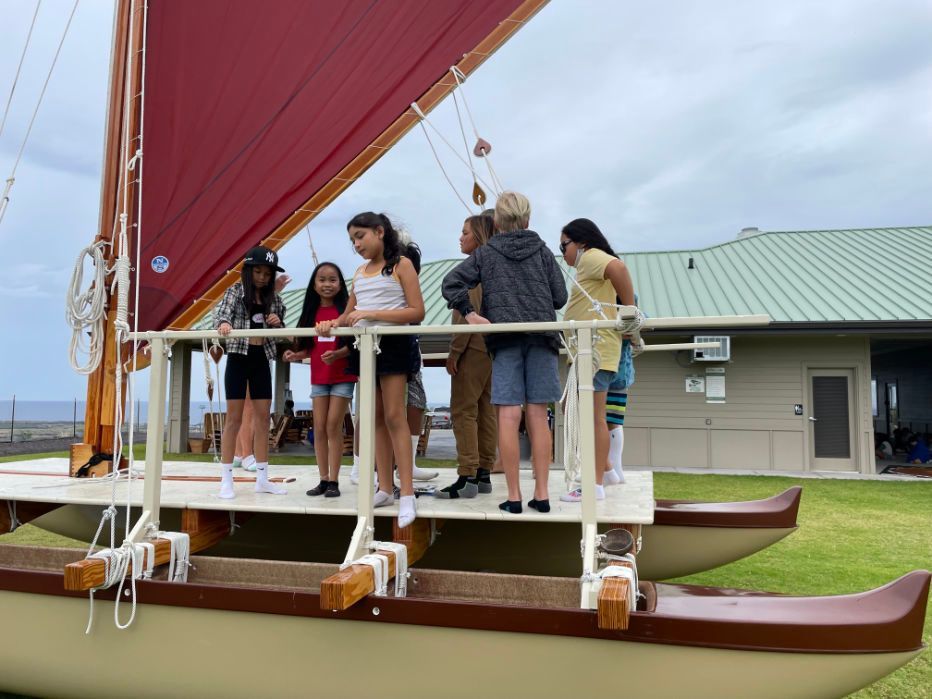 A group of people are standing on the deck of a boat.