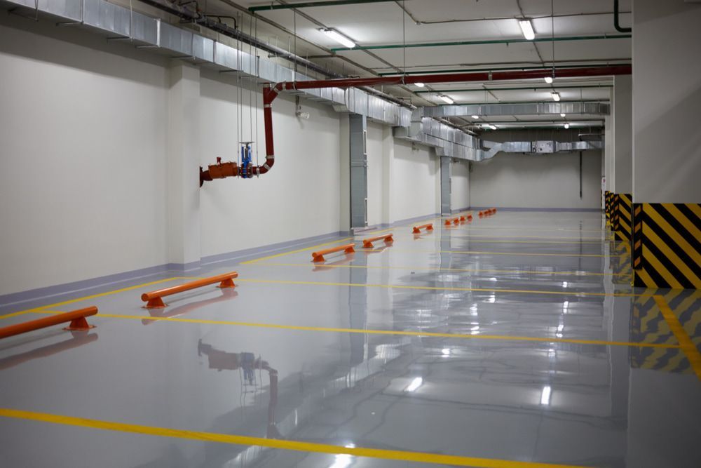 An Empty Parking Garage With A Concrete Floor And Yellow Lines — Corbett Brothers Flooring In Woy Woy, NSW