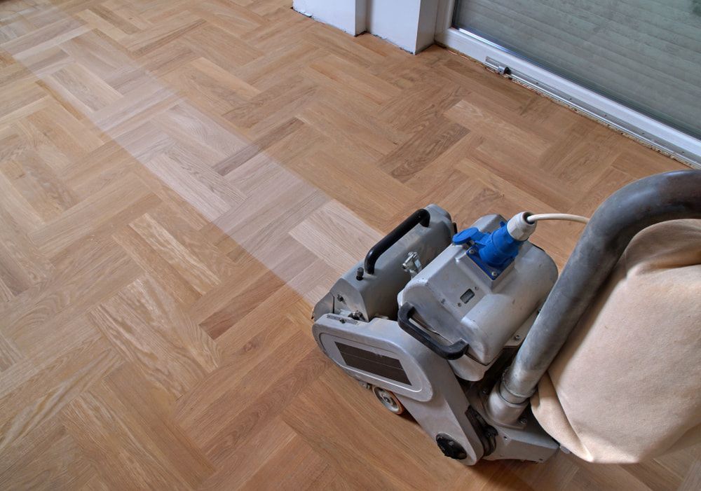 A Machine Is Being Used To Sand A Wooden Floor — Corbett Brothers Flooring In Woy Woy, NSW