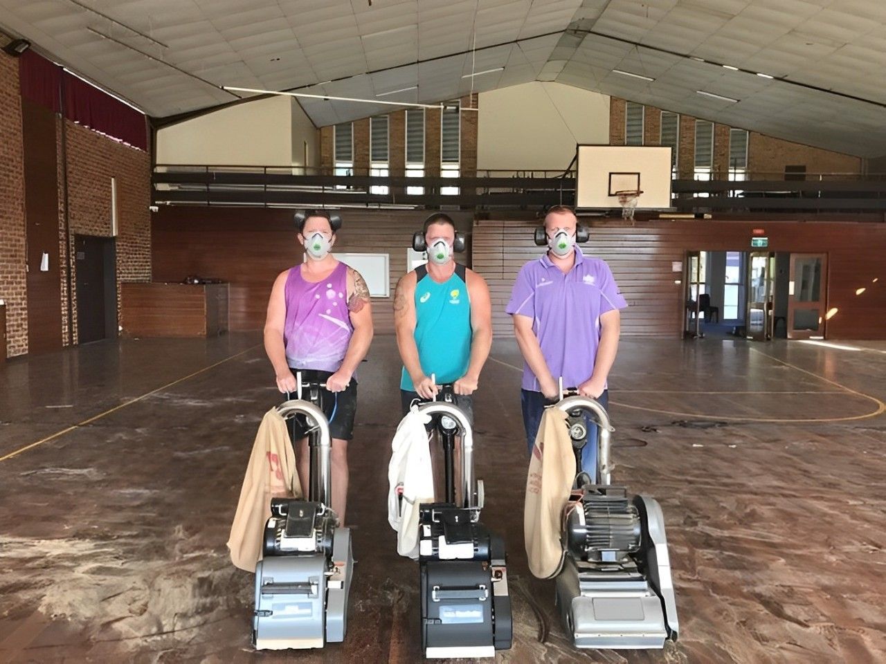 Three People Wearing Masks While Sanding The Floor — Corbett Brothers Flooring In Woy Woy, NSW