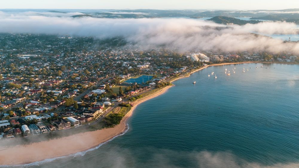 An Aerial View Of A City Surrounded By Water And Clouds — Corbett Brothers Flooring In Woy Woy, NSW