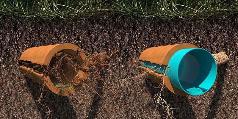 Two pipes are laying in the dirt next to each other.