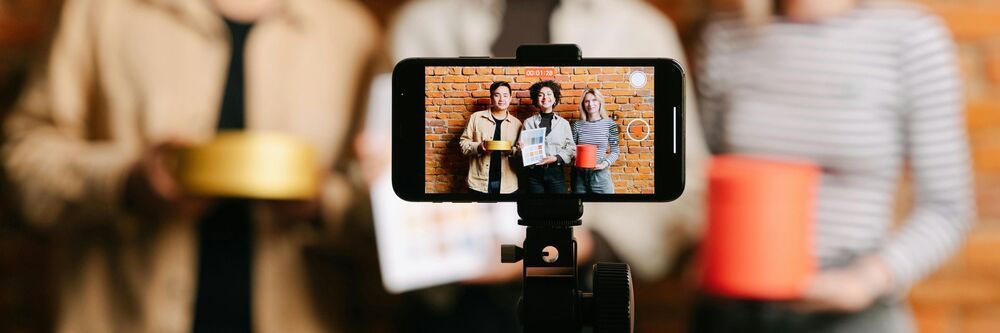 Symbolbild Influencer Marketing, Smartphone zeichnet Video von drei Personen auf (Bild: Pexels)
