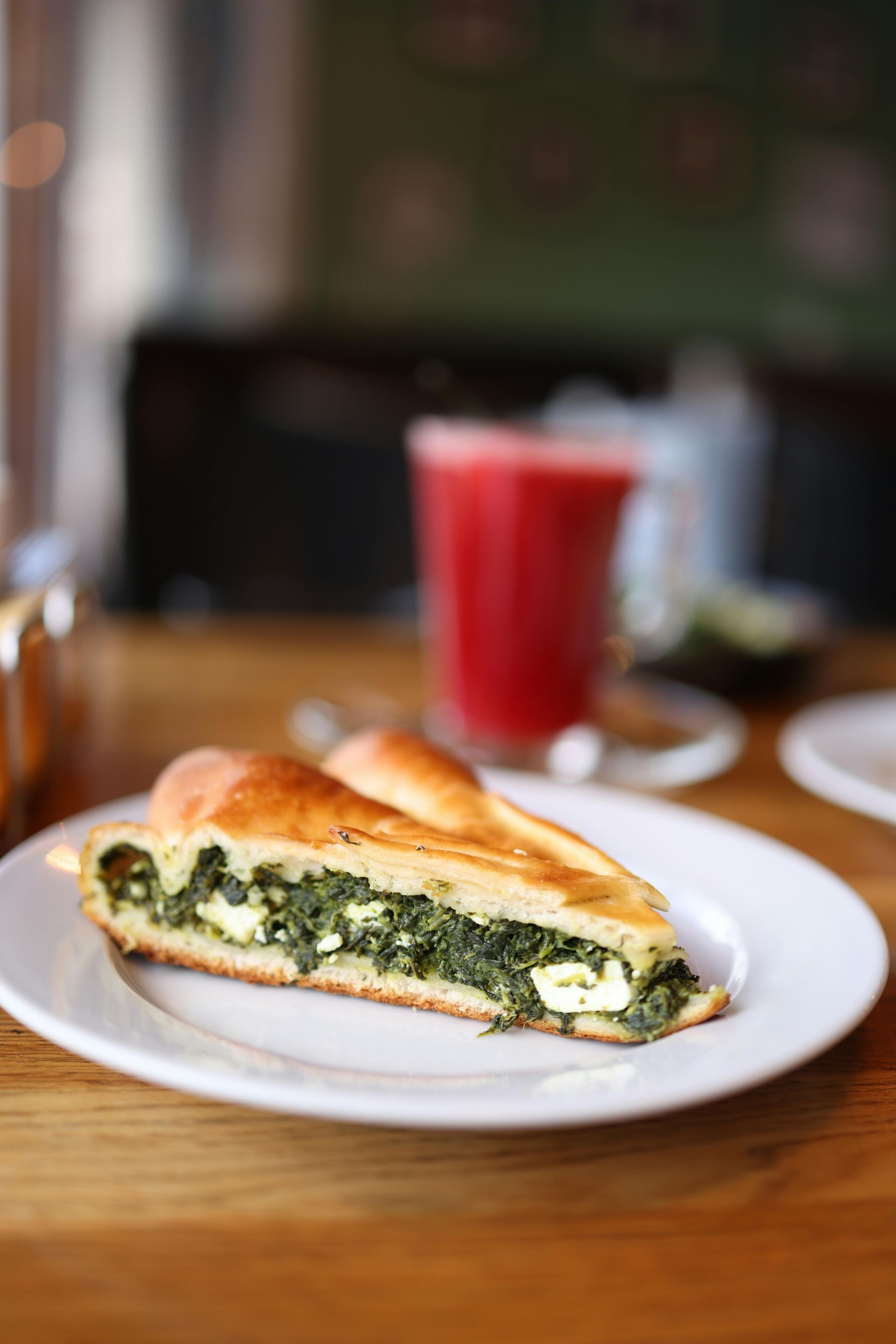 Orange tree laden with ripe, round oranges, set against a backdrop of green leaves and blue sky.
