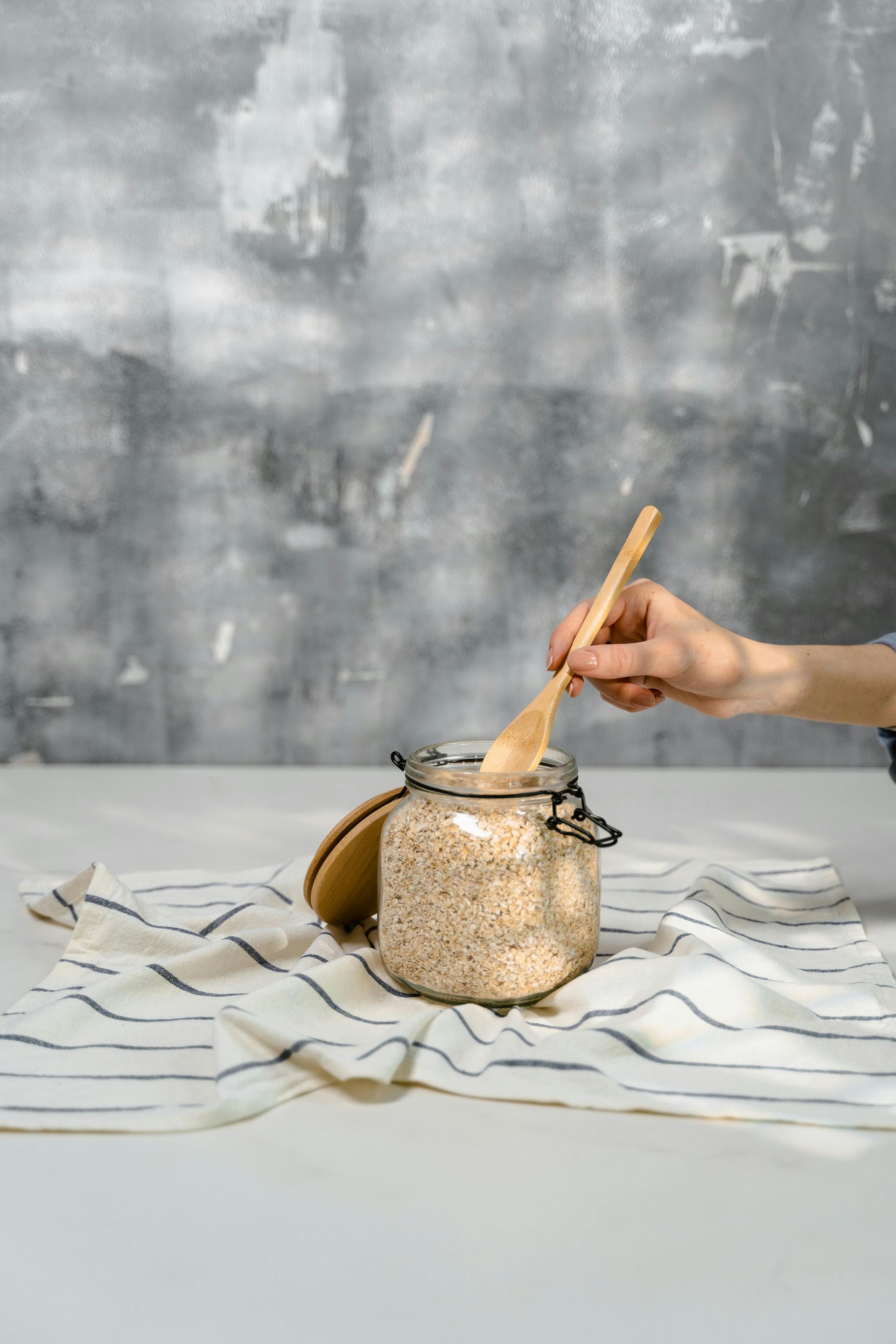 Green leaves and a partially opened walnut in its husk on a tree branch.