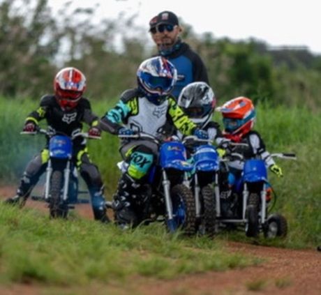 Un grupo de niños aprenden a montar motocross en una pista de motocross