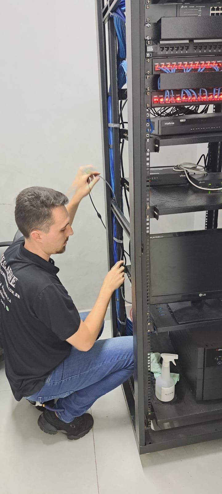 Técnico conectando cabos em rack de rede de computadores