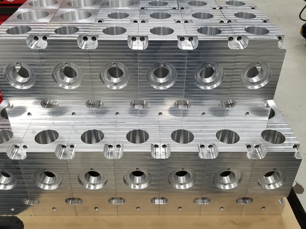 A bunch of metal pieces with holes in them are stacked on top of each other on a table.