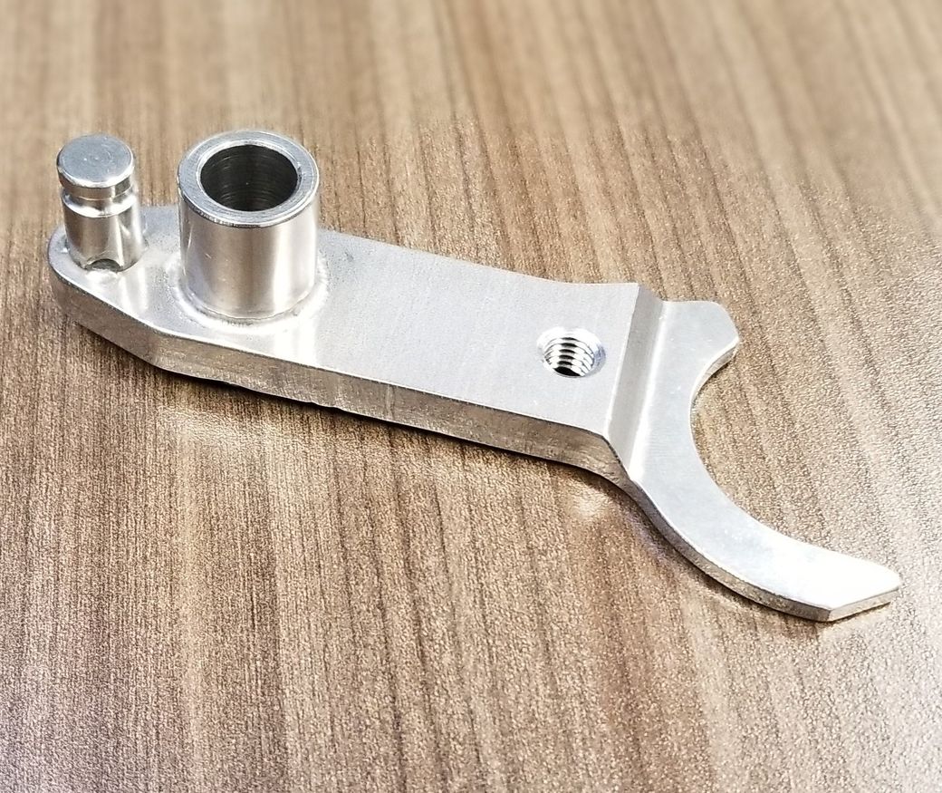 A piece of metal is sitting on a wooden table.