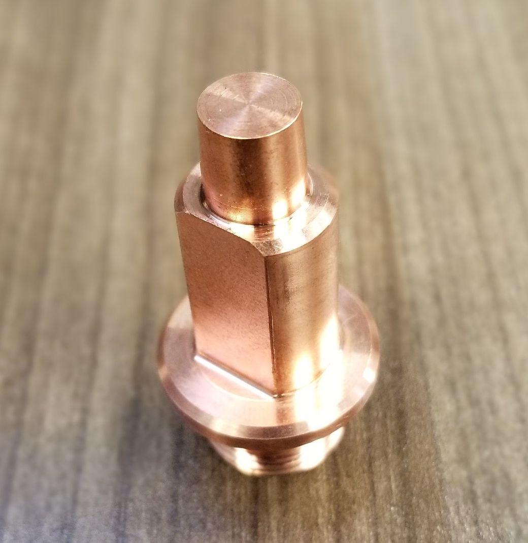 A close up of a copper object on a wooden table.