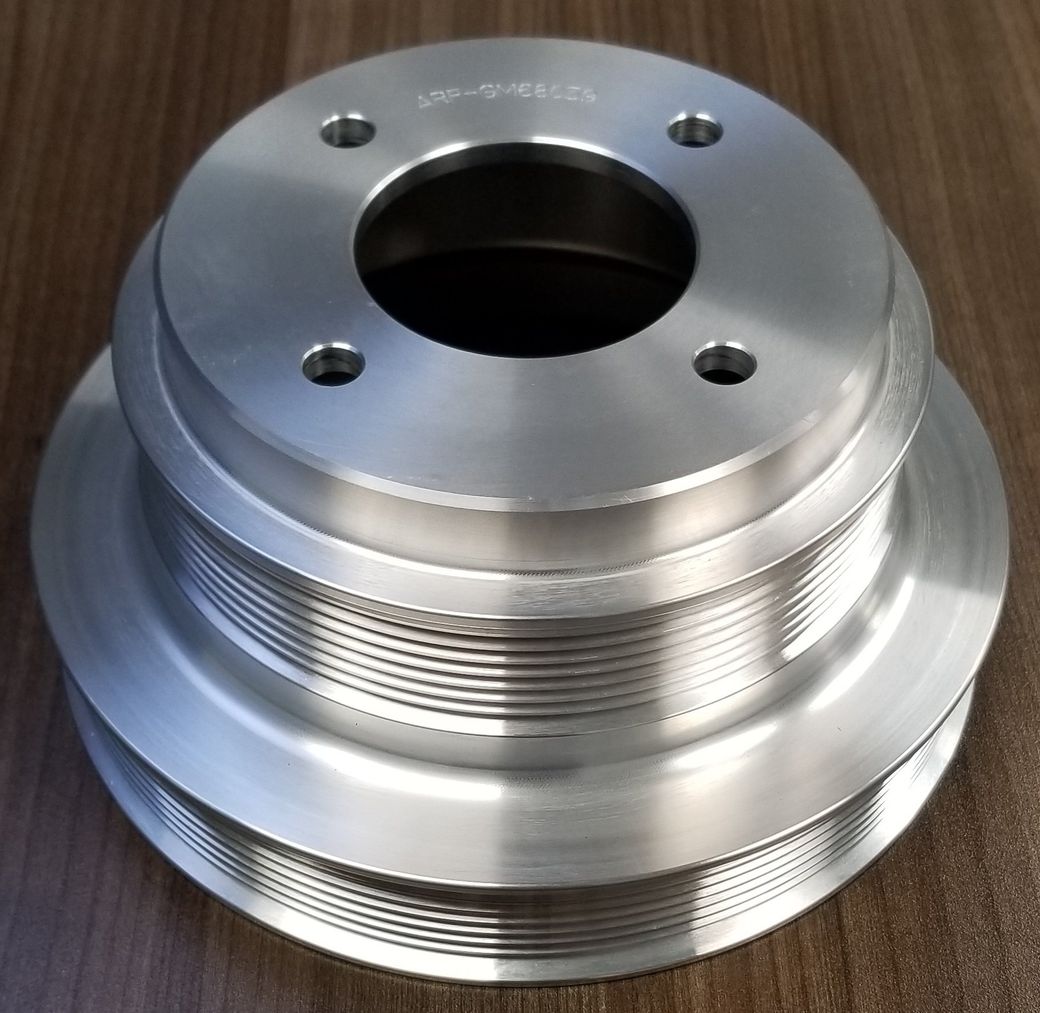 A close up of a stainless steel pulley on a wooden table