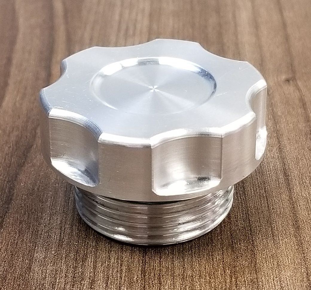 A metal cap is sitting on top of a wooden table.