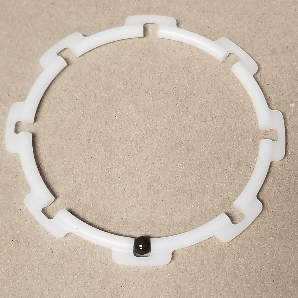 A white plastic ring with a screw in the middle