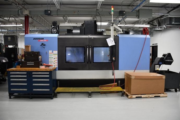 A machine is sitting on a pallet in a factory.