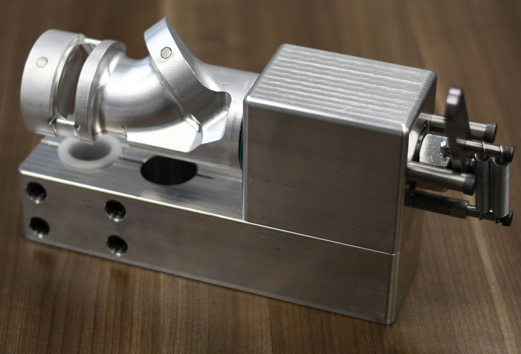A silver metal object is sitting on a wooden table