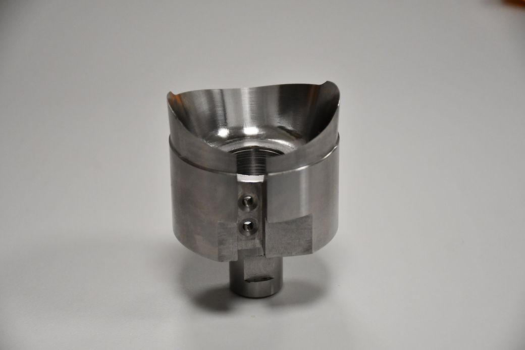 A stainless steel object is sitting on a white surface