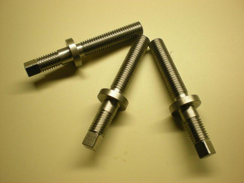 Three stainless steel screws are stacked on top of each other