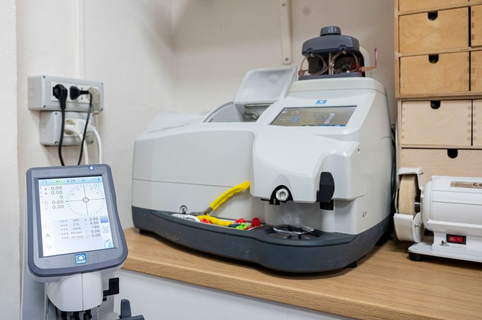 Occhiali da sole esposti su una rastrelliera metallica contro un muro di mattoni. Sono visibili modelli e colori assortiti.