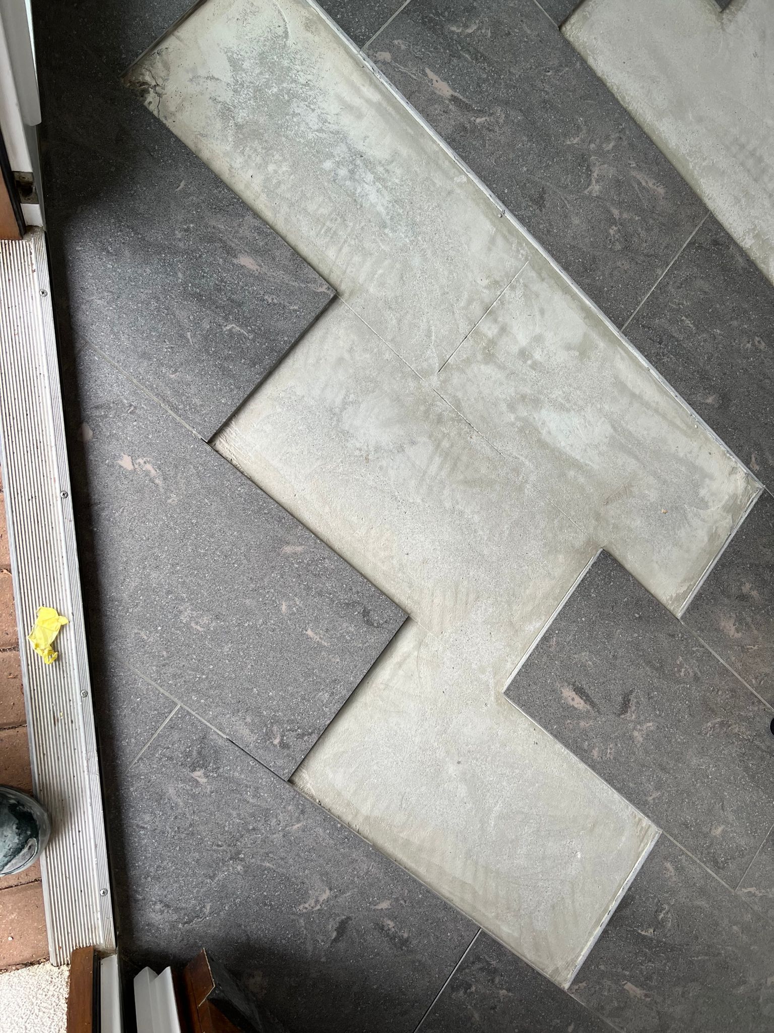 Eine Nahaufnahme eines Fliesenbodens mit Chevron-Muster.