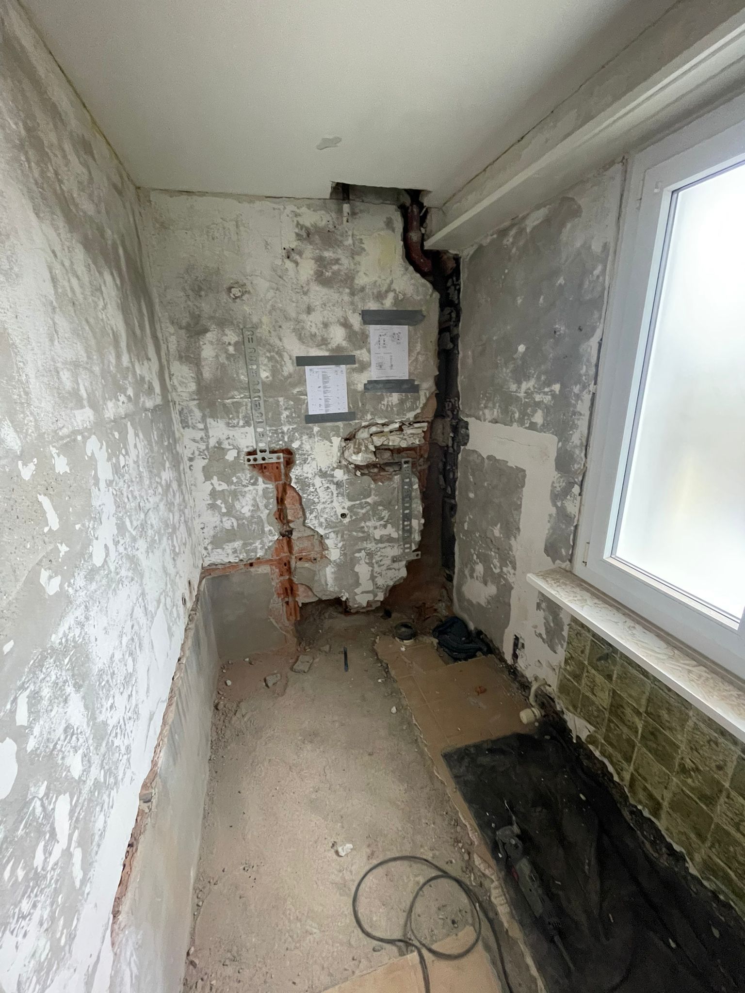 Ein Raum mit abblätternder Farbe an den Wänden und einem Fenster.