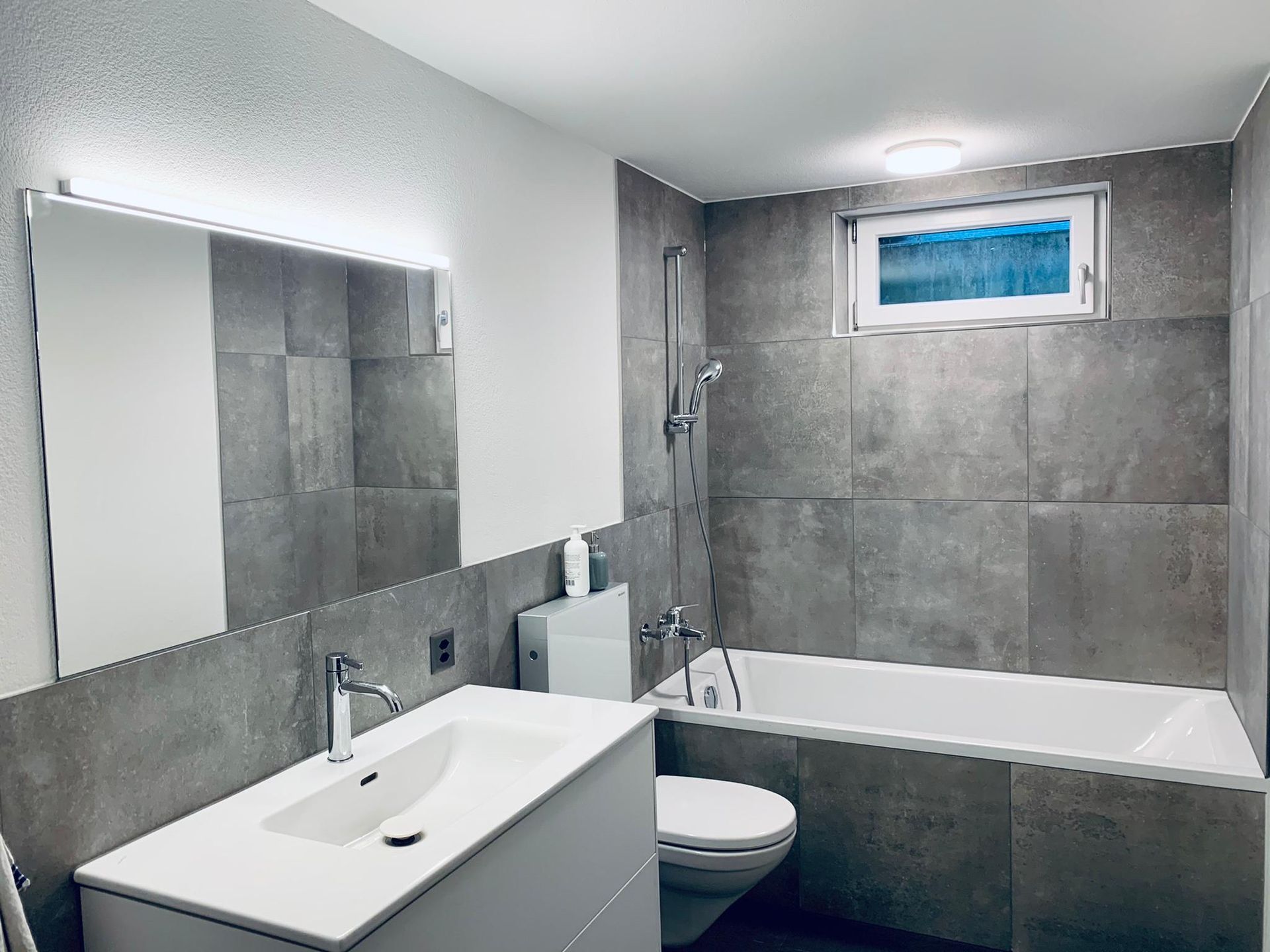 Ein Badezimmer mit Waschbecken, Toilette, Badewanne und Spiegel.