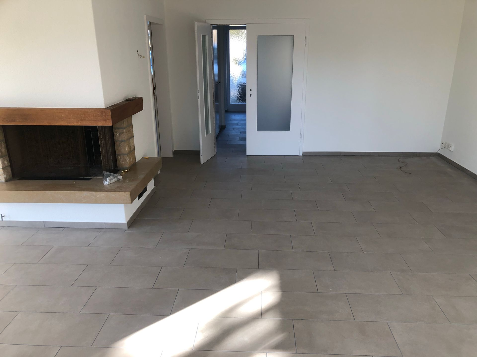 Ein leeres Wohnzimmer mit einem Kamin und einer Tür