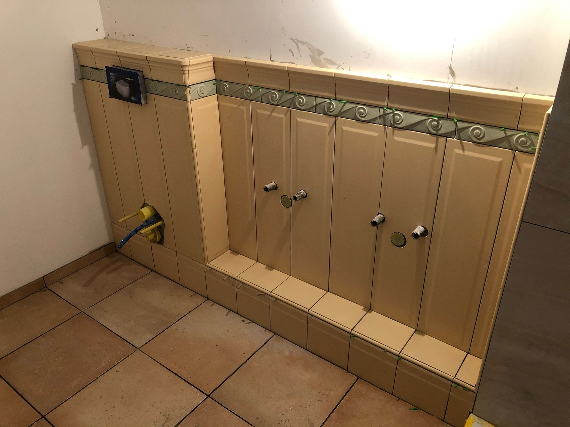 Ein Badezimmer mit gefliestem Boden, Schränken und einer Toilette.