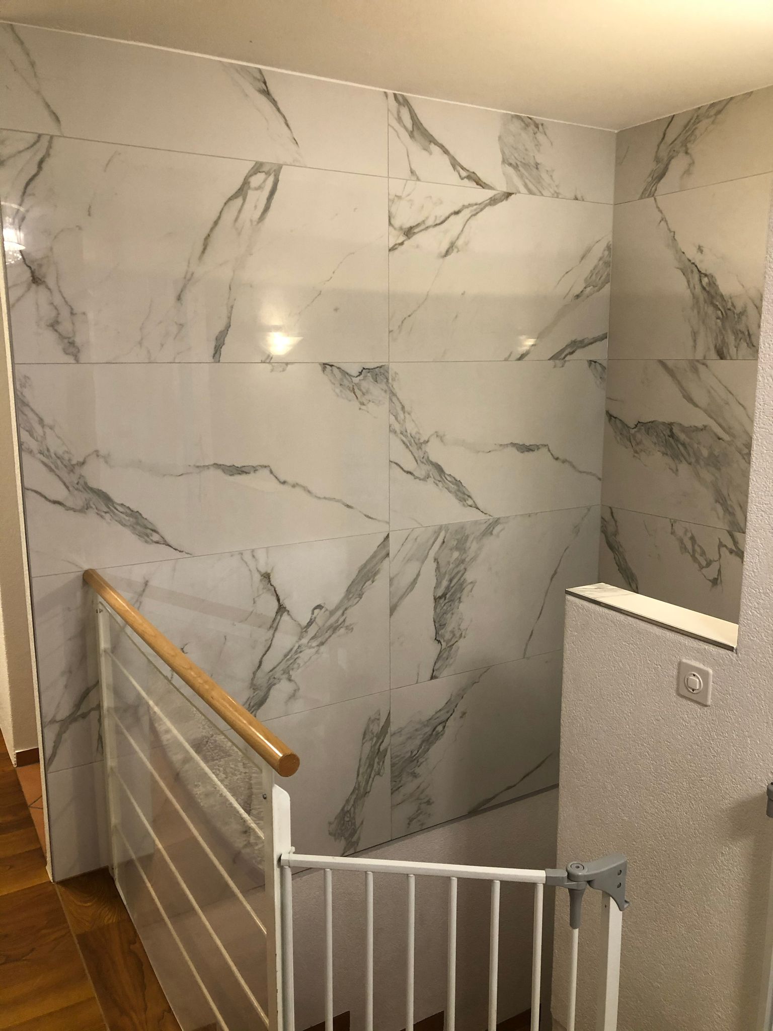 Eine Treppe mit einer Marmorwand und einem Kinderschutzgitter