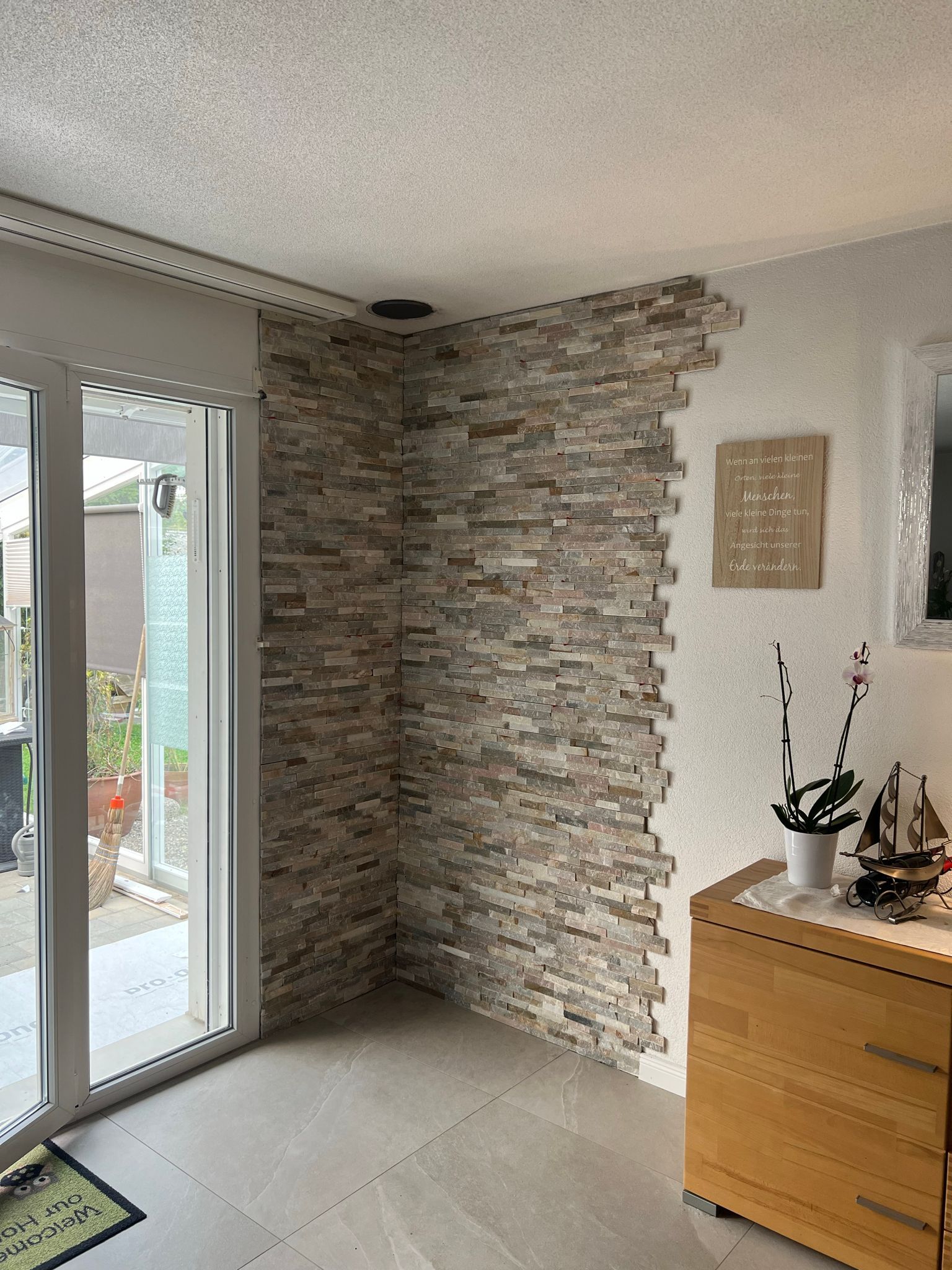 Ein Wohnzimmer mit einer Ziegelwand und einer Glasschiebetür.