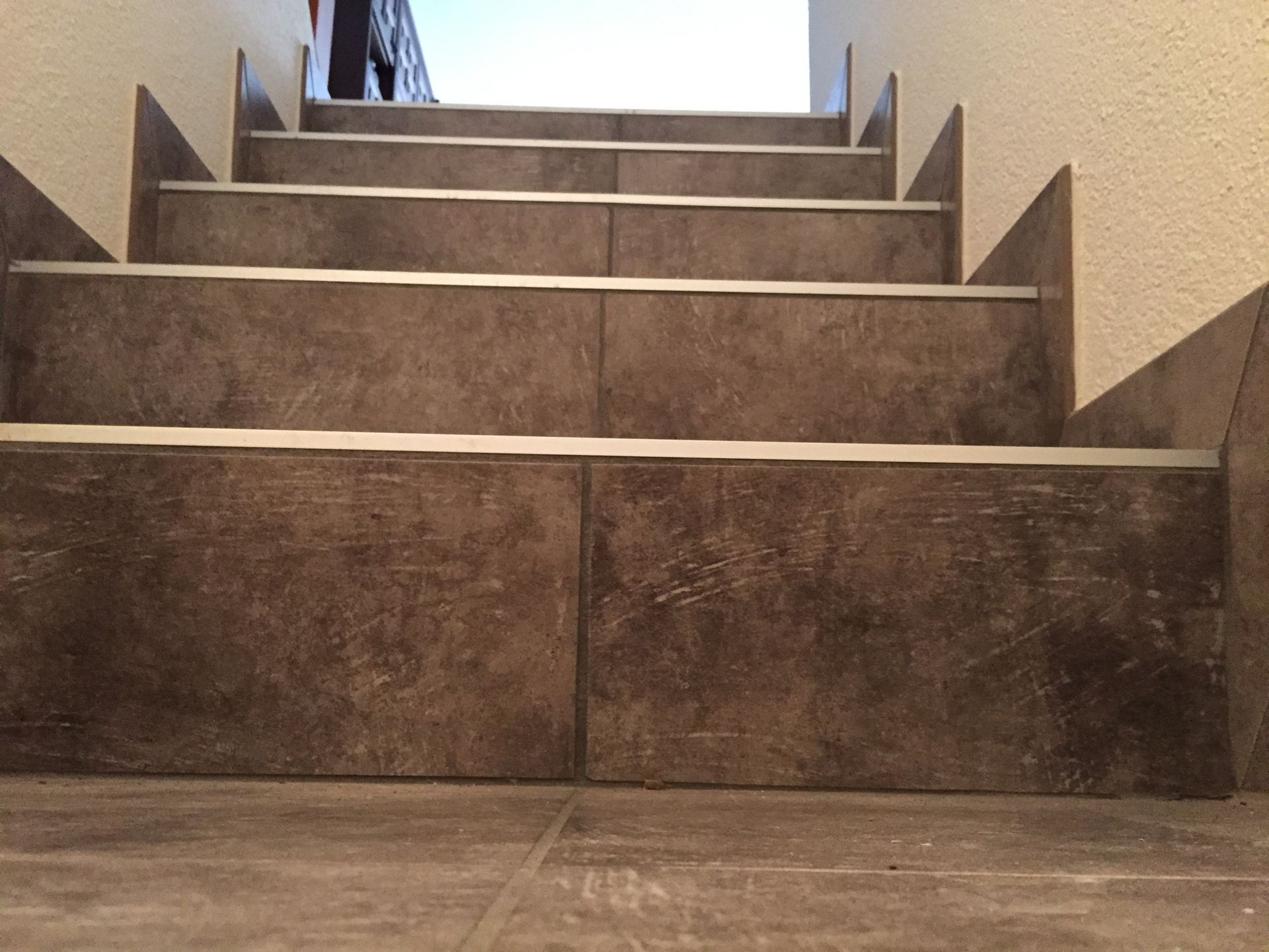 Eine Person geht eine geflieste Treppe hinauf.