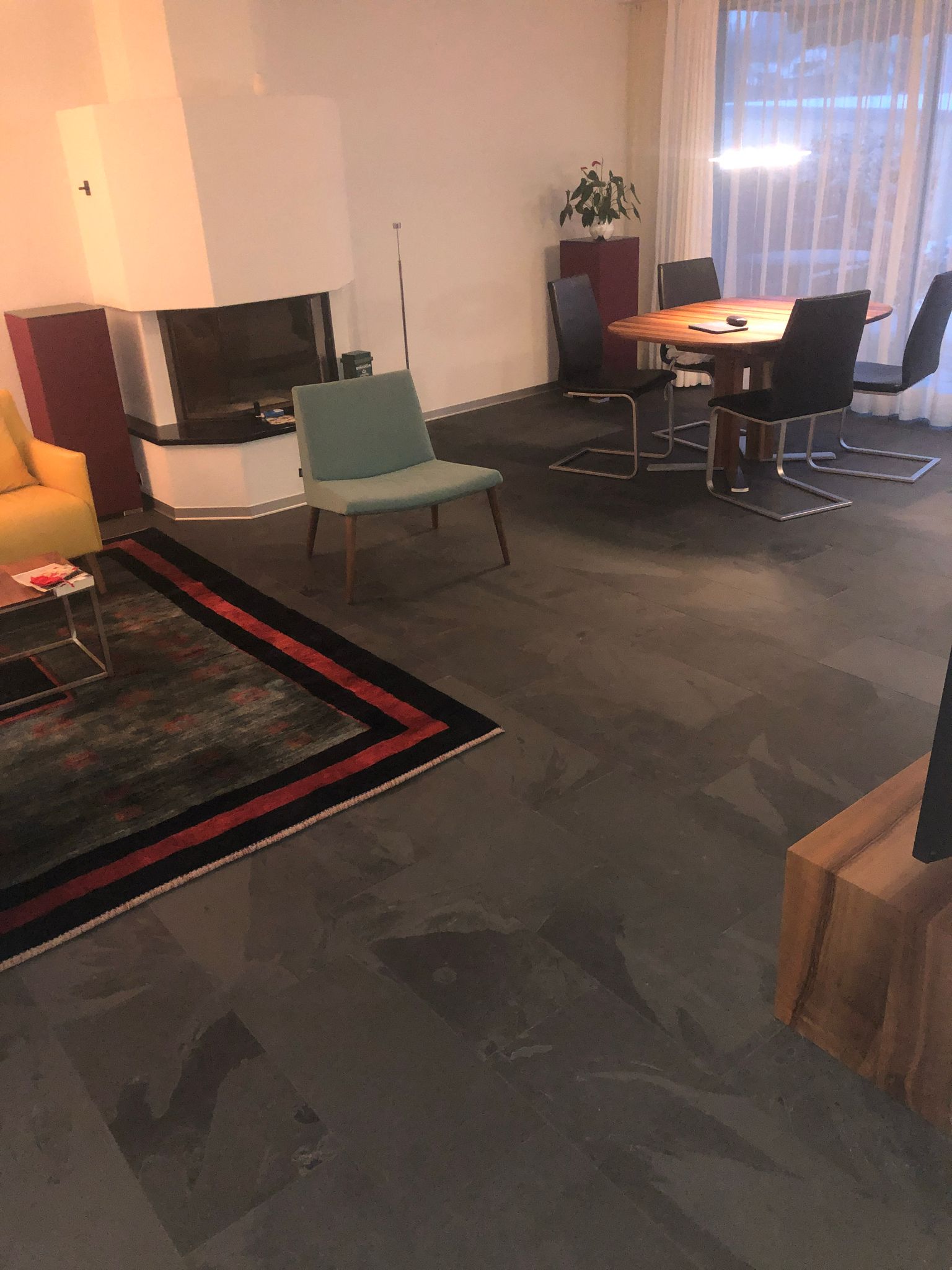 Ein Wohnzimmer mit Tisch und Stühlen und einem Kamin.