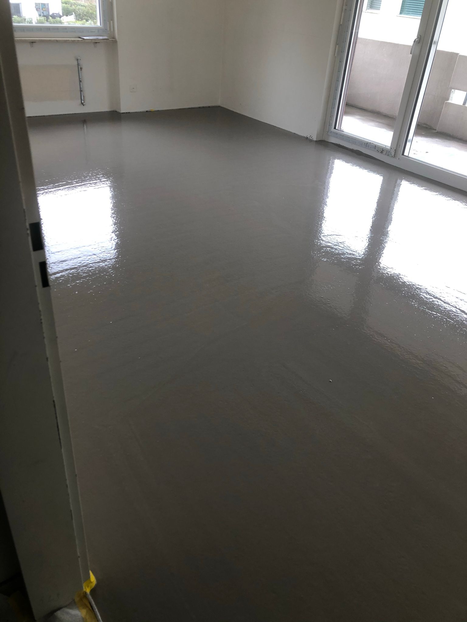 Ein Raum mit glänzendem Boden und Glasschiebetüren.