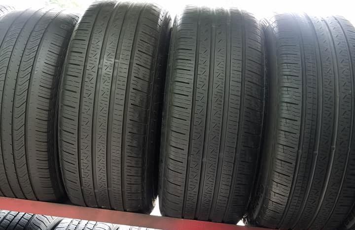 A bunch of tires are stacked on top of each other on a shelf.