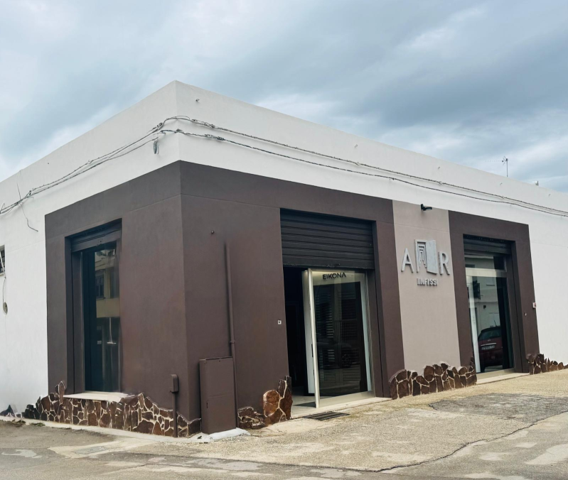 Esterno di un edificio con facciata bianca e marrone, con il nome 