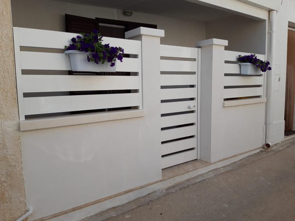 Esterno di un edificio con facciata marrone e bianca; porta d'ingresso visibile; insegna