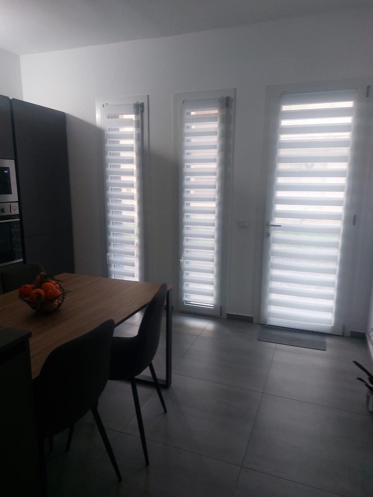 Porta interna bianca, parzialmente aperta, con ferramenta nera, in un ambiente moderno.