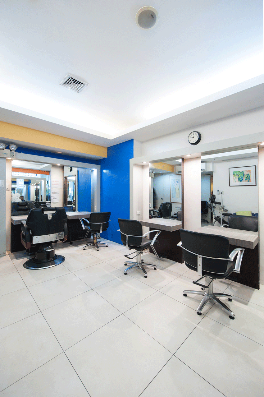 Modern salon at Makati boutique hotel featuring sleek styling stations with blue accent wall