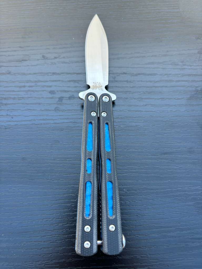 Butterfly knife with a silver blade and black and blue handles.