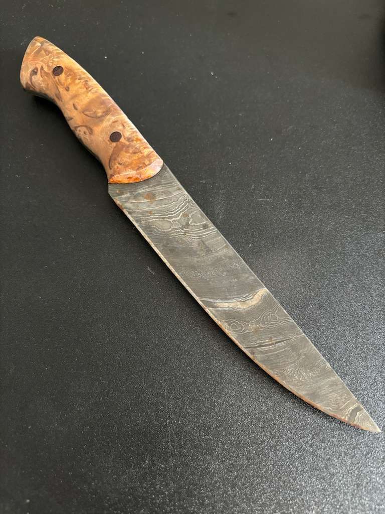 Knife with wooden handle on a dark surface.