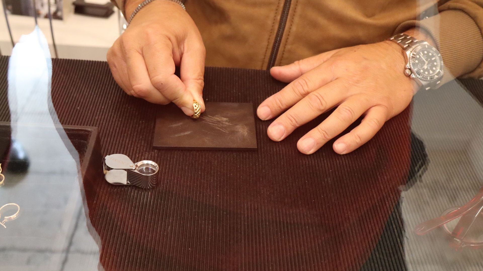 Un uomo che indossa un orologio tiene in mano un anello.