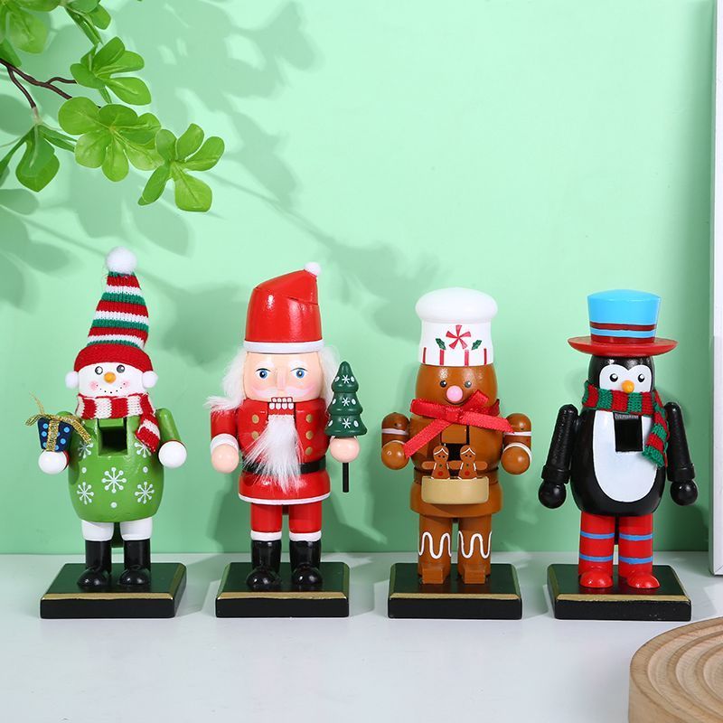 Cuatro cascanueces navideños: un muñeco de nieve, un Papá Noel, un cocinero de jengibre y un pingüino sobre una mesa.