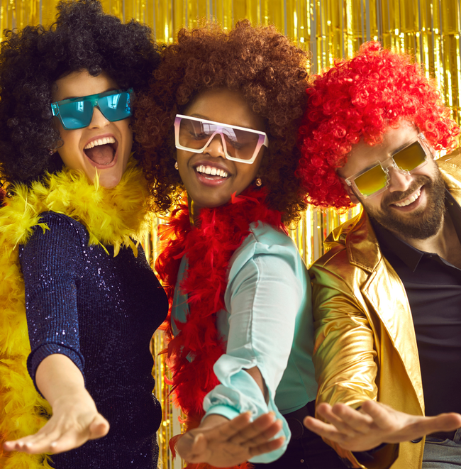 Three people wearing wigs and sunglasses are posing for a picture